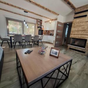 a living room with a table and a fireplace at Planinska kuća Aurahill-Blidinje in Blidinje