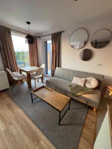 a living room with a couch and a table at Sonińskie Wzgórze Domki 