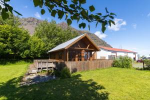 a cabin in a field with a mountain in the background at Hali Country Hotel in Gerdi