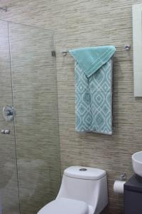 a bathroom with a toilet and a glass shower at 2br/2ba Condo 1 block to ocean! - Unit 3 in Mazatlán +23 photos