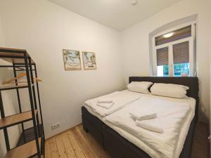 a bedroom with a bed with white sheets and a ladder at Gemütliche Stadtwohnung im Zentrum in Weinheim