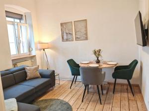 a living room with a couch and a table and chairs at Gemütliche Stadtwohnung im Zentrum in Weinheim