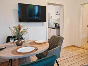 a dining room with a table with chairs and a television at Gemütliche Stadtwohnung im Zentrum in Weinheim
