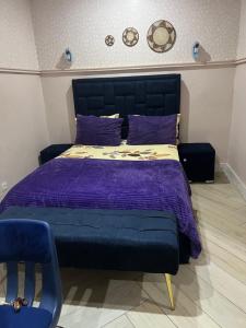 a bedroom with a bed with purple sheets and a chair at MAISON Khadija Abibatou in Dakar
