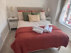 a bedroom with a bed with two towels on it at Historic High St Flat with Peaceful Garden Retreat in Stony Stratford