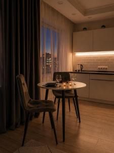 a dining room with a table and chairs and a kitchen at Студия Назарбаева 57 in Kokshetau +2 photos