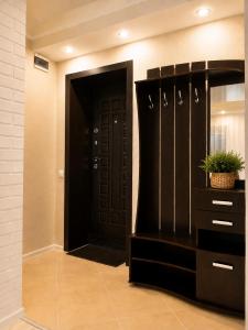 a hallway with a black door and a cabinet with a plant at Студия Назарбаева 57 in Kokshetau