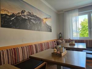 a restaurant with two tables and a large picture on the wall at Pension Schachner in Schladming +57 photos