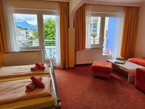 a hotel room with two beds and a balcony at Pension Schachner in Schladming