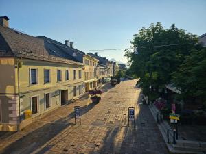 a cobblestone street in a town with vehicles on it at Pension Schachner in Schladming