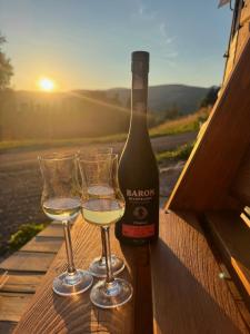 a bottle of wine and two glasses on a table at Chata Borůvka in Pec pod Sněžkou
