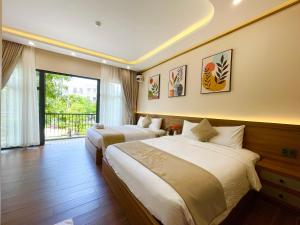 a hotel room with two beds and a balcony at Vin Luxury Hotel in Quang Tri