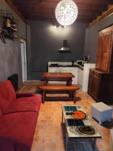 a living room with a red couch and a table at Au Clairon in Lamotte-Beuvron
