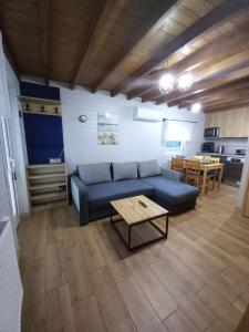 a living room with a blue couch and a table at Amelia Domek letniskowy in Mechelinki +5 photos