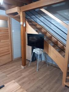 a loft bed with a desk and a computer monitor at Amelia Domek letniskowy in Mechelinki