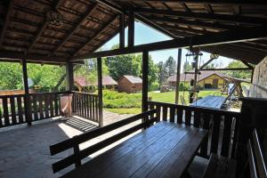 a wooden bench on a porch with a view of a yard at Penzión Hôrka in Vinné