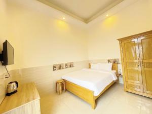 a bedroom with a bed and a tv in it at Dalat Mist House - Đà Lạt in Da Lat