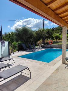 a swimming pool with chairs and a wooden roof at Casa da Pinha in Ponte da Barca +36 photos