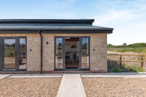 a small brick house with sliding glass doors at Kent Coast Stays - Cottages in Birchington
