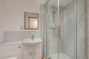 a white bathroom with a sink and a shower at Kent Coast Stays - Cottages in Birchington +29 photos