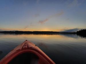 a view from the inside of a kayak on a lake at sunset at Historic lakeside villa - sauna, ski, boat, 20 guests in Sunnansjö