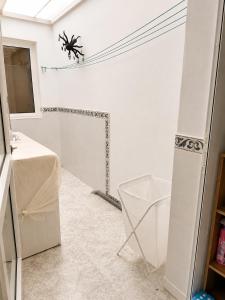 a white bathroom with a spider on the ceiling at Roca Mogán in Puerto de Mogán +4 photos