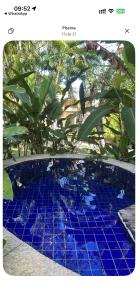 a swimming pool with blue tiles on the ground at Bangalô Villas do Pratagy - Flor de Lótus B1 in Maceió