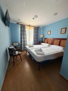 a bedroom with two beds and a chair in it at posada trastamara in Piedralaves