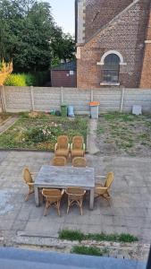 a table with four chairs and a table and a table and chairs at Vakantiewoning Goed Thuis in Dilsen-Stokkem