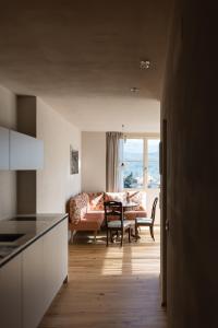 a kitchen and living room with a couch and a table at Essa Suites - NEW in Caldaro