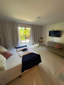 a large bedroom with a large bed and a couch at Bangalô Villas do Pratagy - Flor de Lótus B1 in Maceió +12 photos