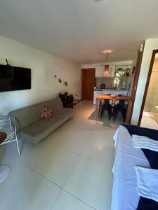 a living room with a couch and a dining room at Bangalô Villas do Pratagy - Flor de Lótus B1 in Maceió