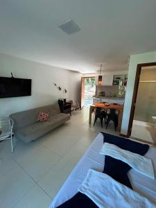 a living room with a couch and a table at Bangalô Villas do Pratagy - Flor de Lótus B1 in Maceió