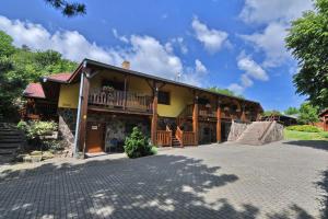 a house with a porch and a driveway at Penzión Hôrka in Vinné