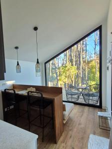 a room with a table and chairs and a large window at Bosque Cipreses Sur in San Carlos de Bariloche