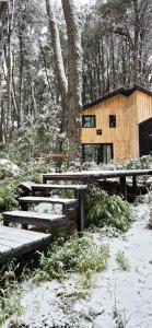 a cabin in the woods with snow on the ground at Bosque Cipreses Sur in San Carlos de Bariloche