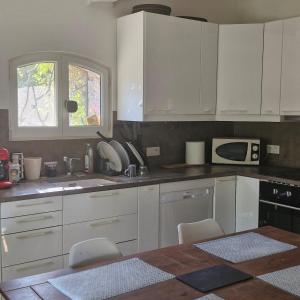 a kitchen with white cabinets and a table with chairs at Pollart in Les Arcs sur Argens