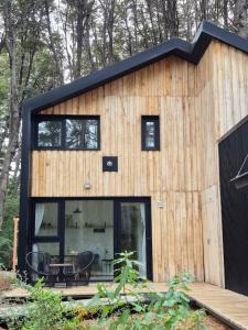 a small house with a black roof at Bosque Cipreses Sur in San Carlos de Bariloche