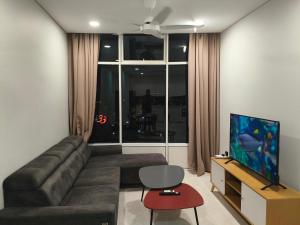 a living room with a couch and a flat screen tv at Klcc vortex runner in Kuala Lumpur