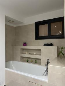 a white bath tub in a bathroom with a sink at Sunny Suites Madagascar in Antananarivo +24 photos