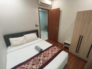 a bedroom with a large bed and a wooden door at Klcc vortex runner in Kuala Lumpur