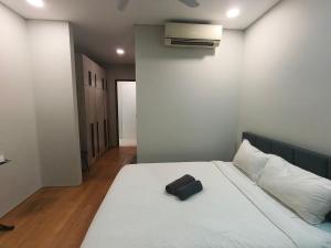 a bedroom with a white bed with a black bag on it at Klcc vortex runner in Kuala Lumpur