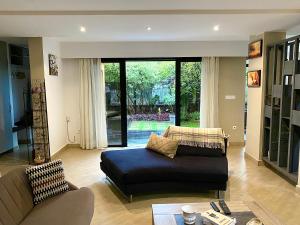 a living room with a couch and a large window at Sunny Suites Madagascar in Antananarivo