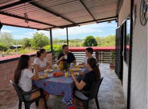 a group of people sitting around a table on a patio at Diamante 38 in La Dorada