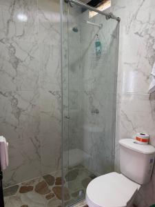 a bathroom with a glass shower with a toilet at Diamante 38 in La Dorada