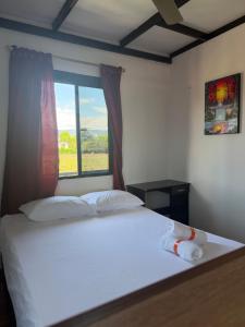 a bedroom with a white bed with a window at Diamante 38 in La Dorada