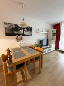 a dining room with a wooden table and chairs at Ferienwohnung Talblick in Sankt Englmar