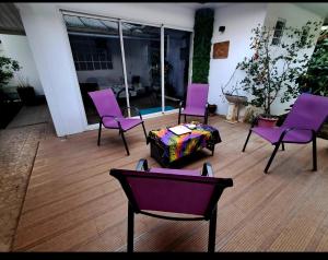 a group of purple chairs and a table in a room at Uvini's Mahina Lodge in Mahina