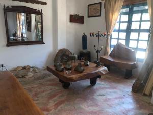 a living room with a table and a chair and a mirror at Casa de Playa Madeleyne in Taganga
