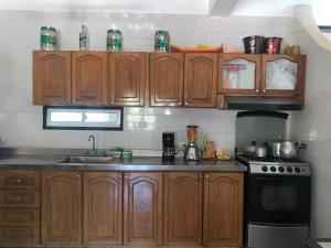 a kitchen with wooden cabinets and a stove at Casa de Playa Madeleyne in Taganga
